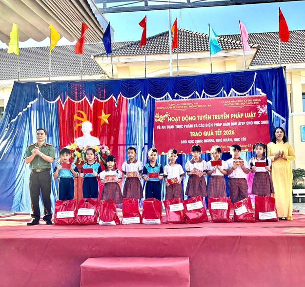 Lãnh đạo xã Phú Riềng và Công an tỉnh trao quà cho các em học sinh