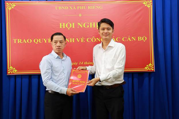 Lãnh đạo UBND xã Phú Riềng trao quyết định cho các cán bộ